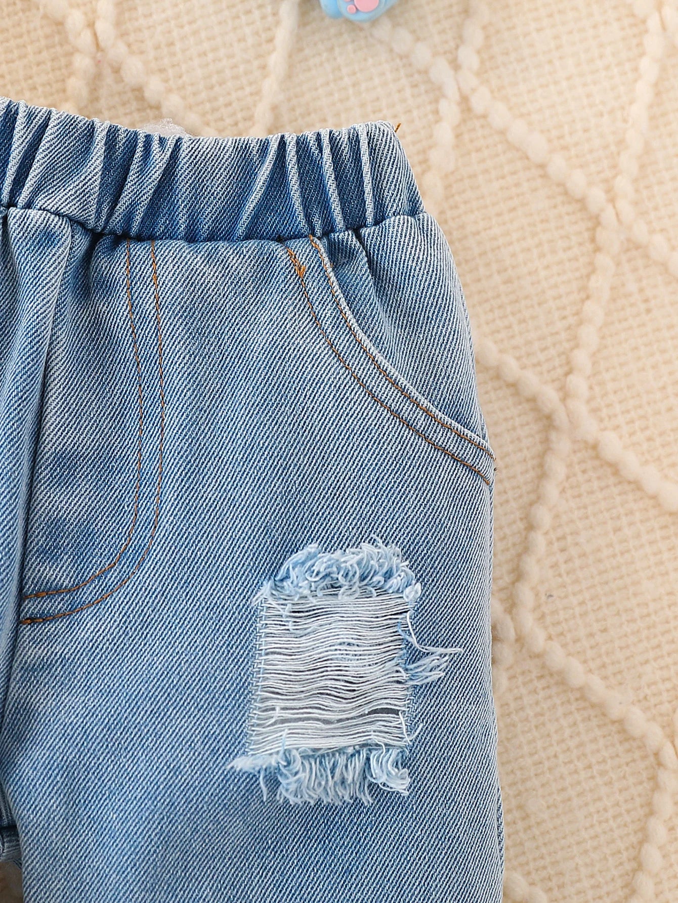 Close-up material detail of baby elephant appliqué quilted sweatshirt and joggers set