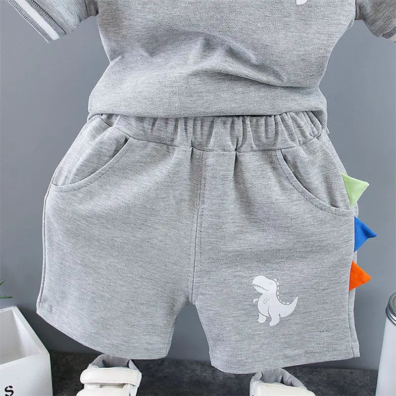 Baby boy wearing a dinosaur print t-shirt and matching shorts
