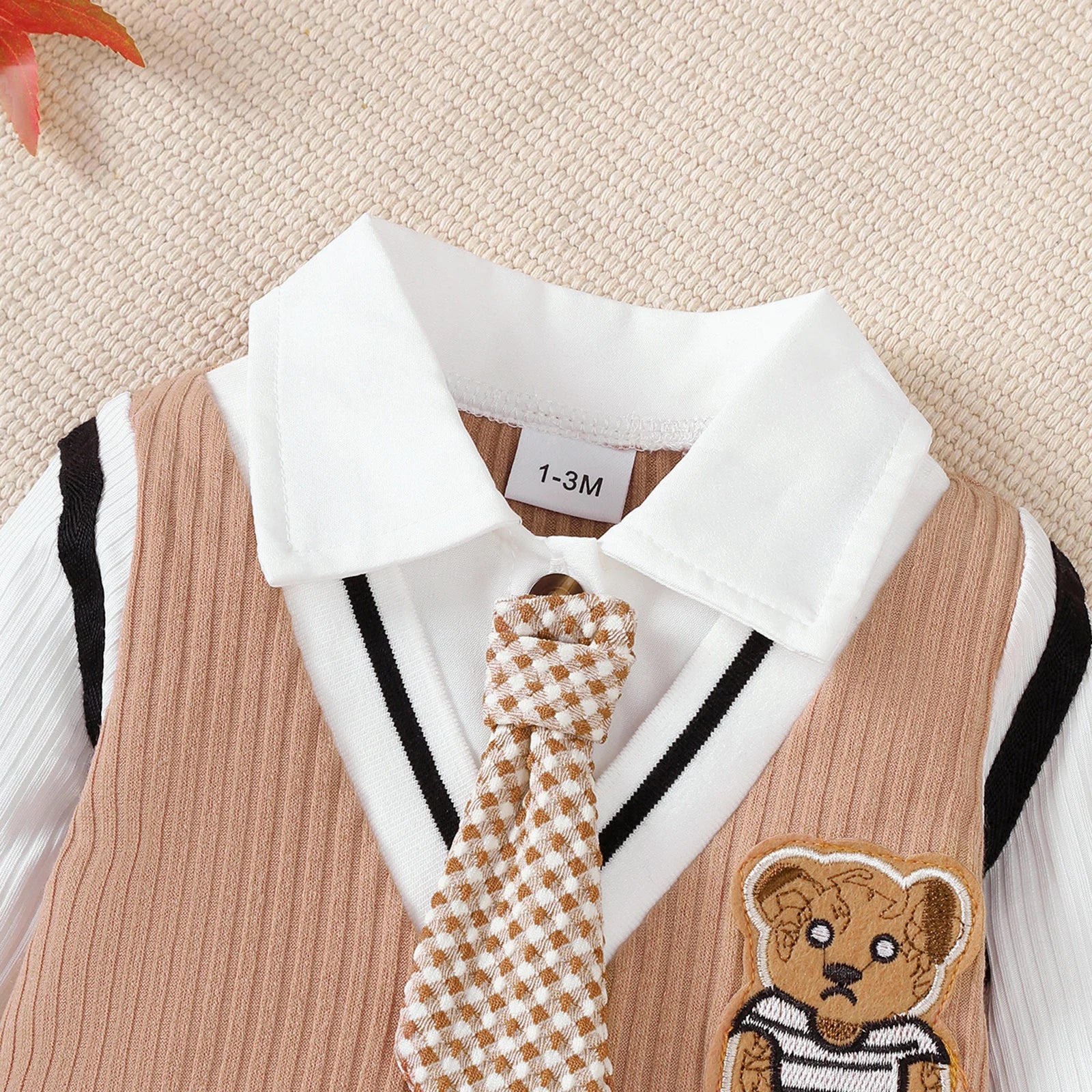 Baby boy wearing a smart short-sleeve romper with an attached tie