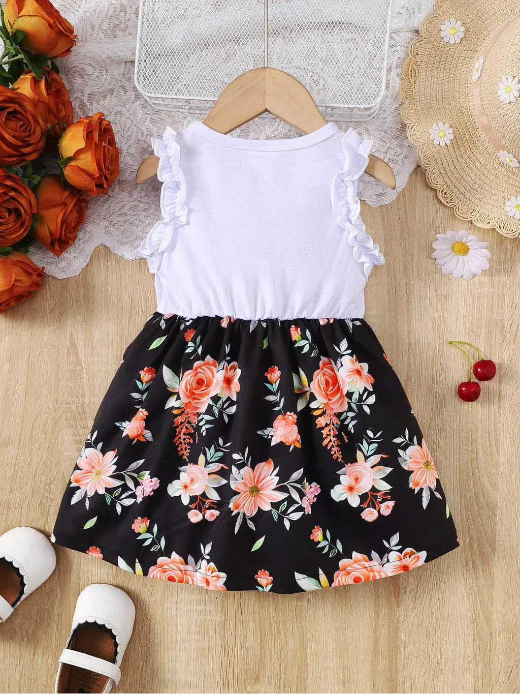 Baby girl wearing a sleeveless floral party dress with a bow