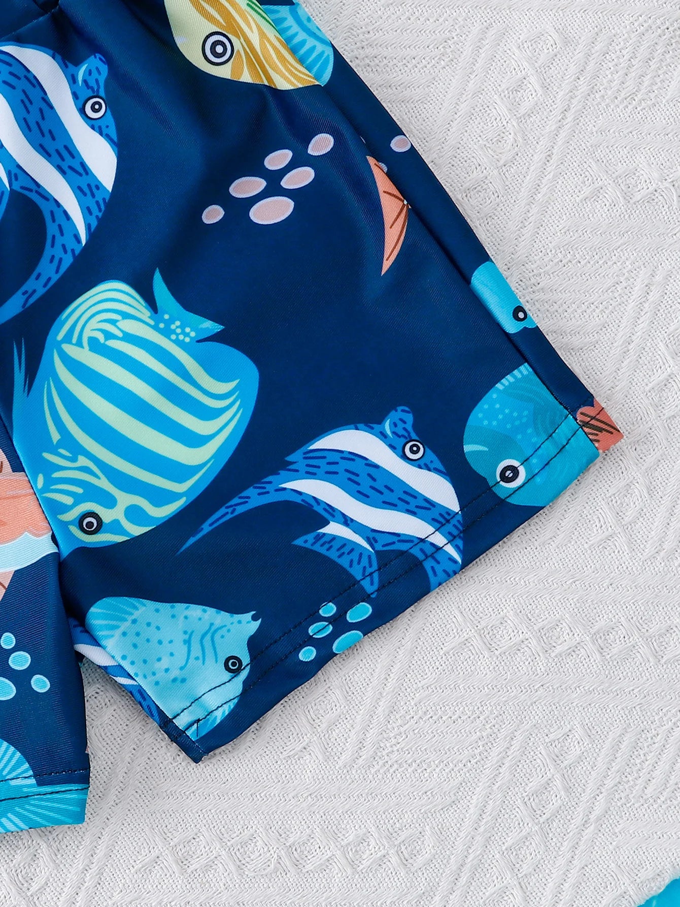 Close-up material detail of boys shark print short sleeve swimwear set