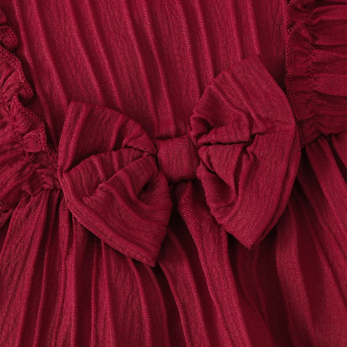 Baby girl wearing a solid colour sleeveless dress with ruffled edges and a headband