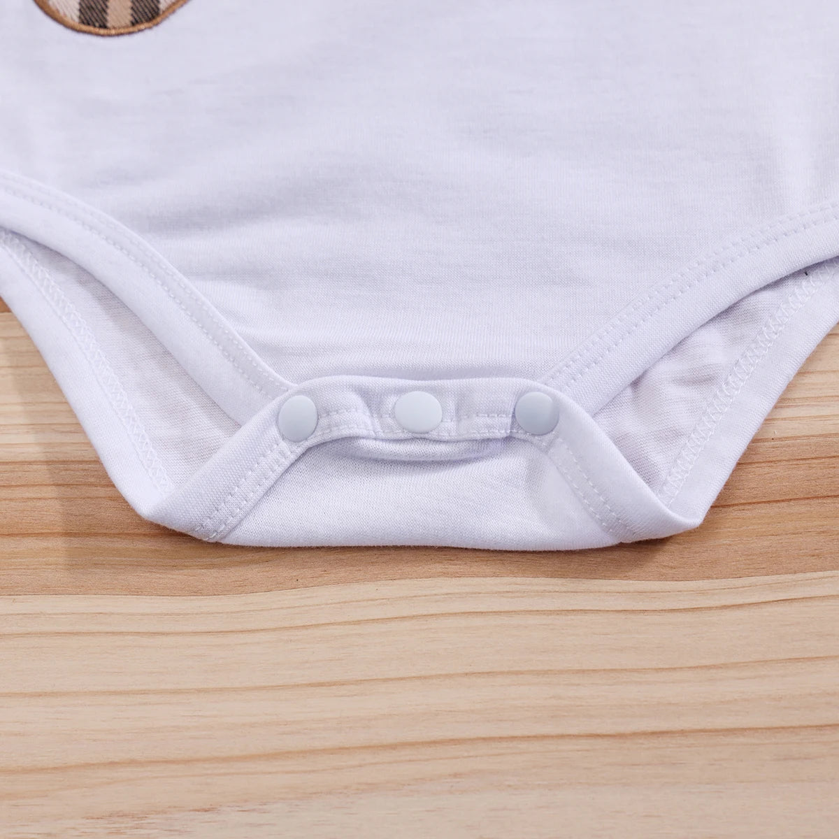 Fabric and texture detail of baby boys plaid bear bodysuit & trousers set