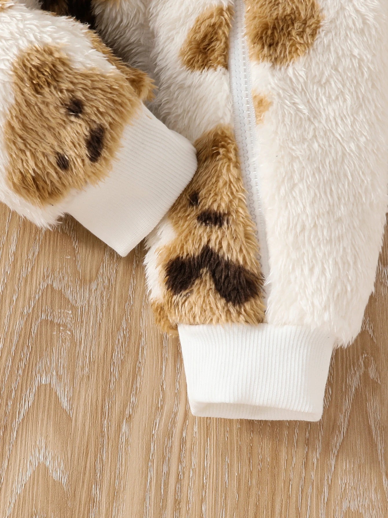 Side or lifestyle view of baby girls fluffy teddy bear print onesie