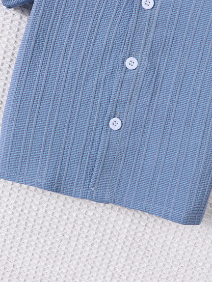 Close up highlighting the hem and stitching on the baby boys woven jacquard shirt and shorts set