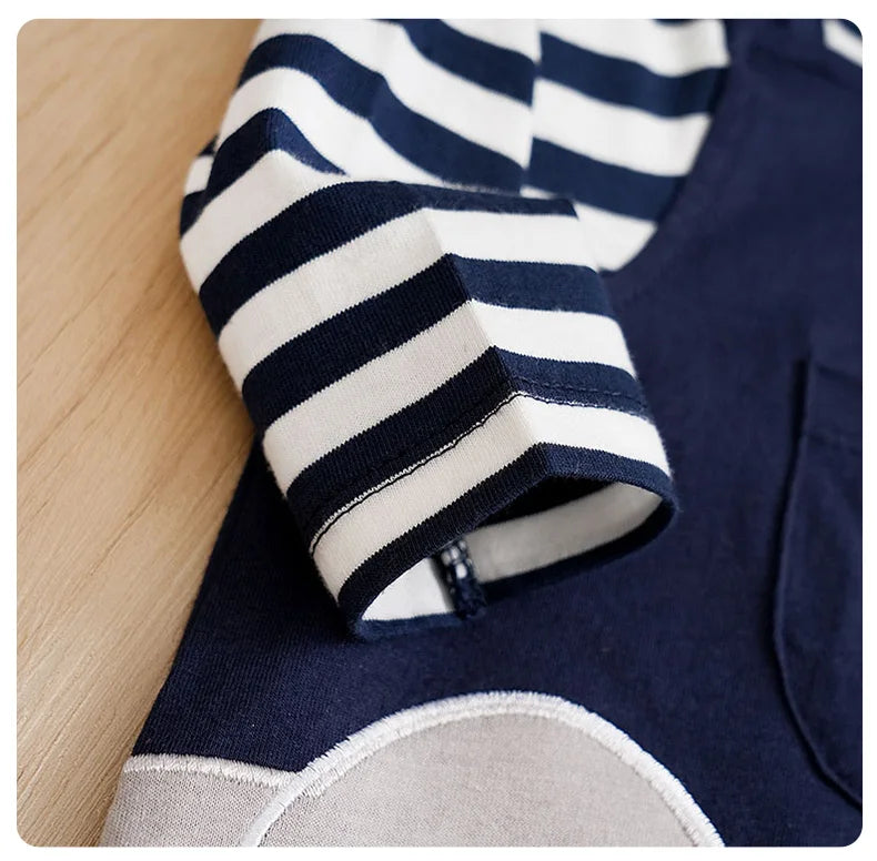 Close up highlighting the hem and stitching on the baby striped elephant and giraffe print romper