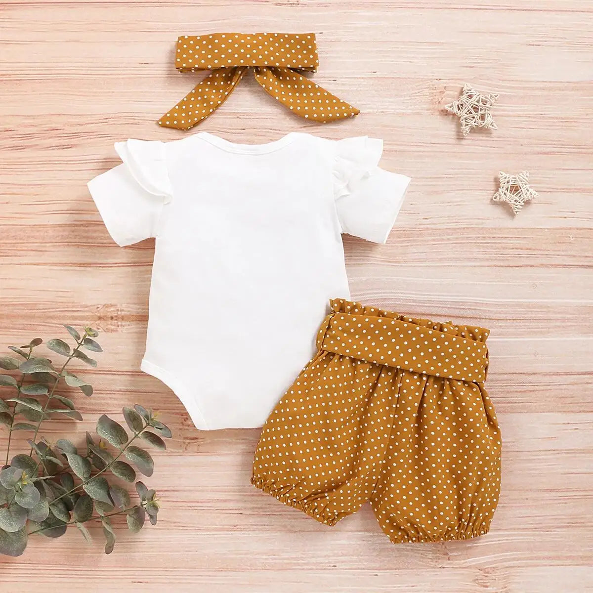 Side view of baby girls romper & polka dot trousers set