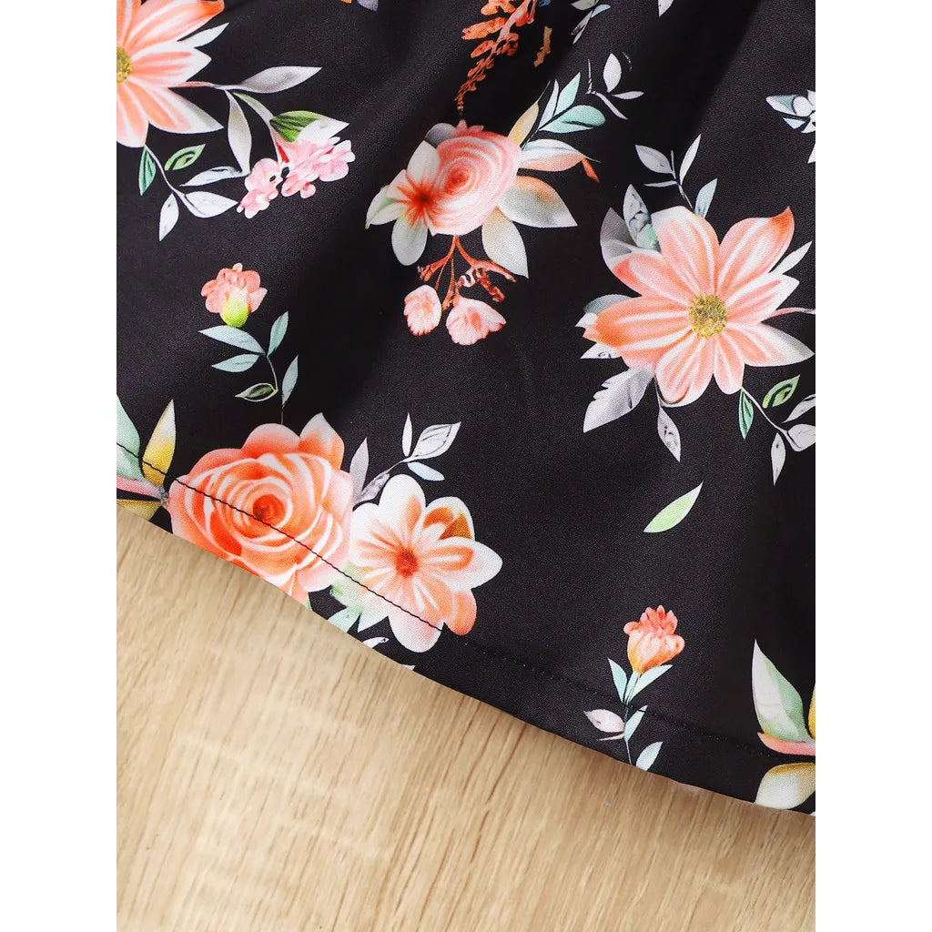 Baby girl wearing a sleeveless floral party dress with a bow