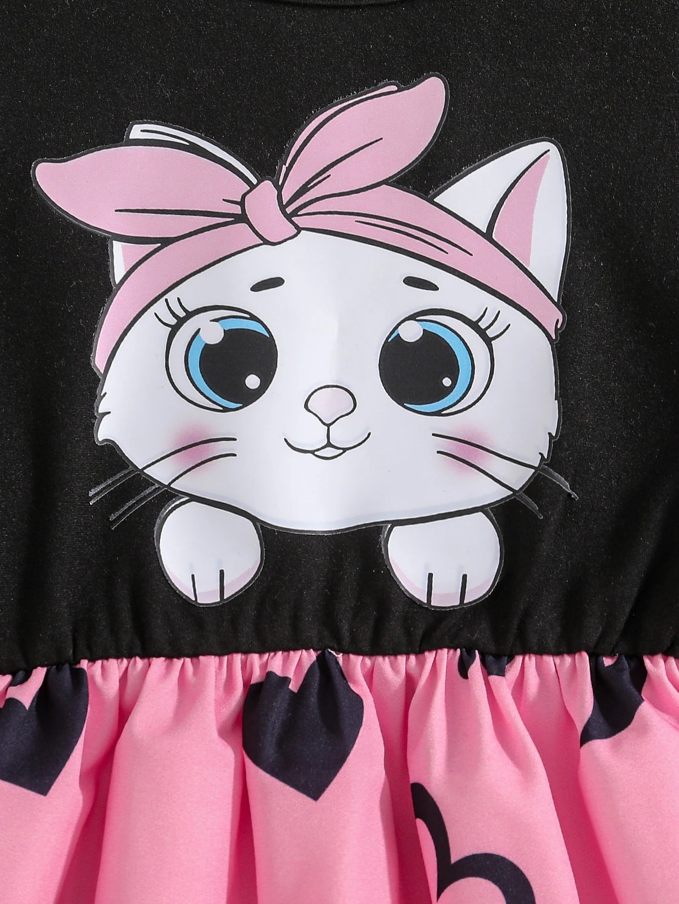 Girl wearing a mid-length dress with a cat and heart print and flutter sleeves