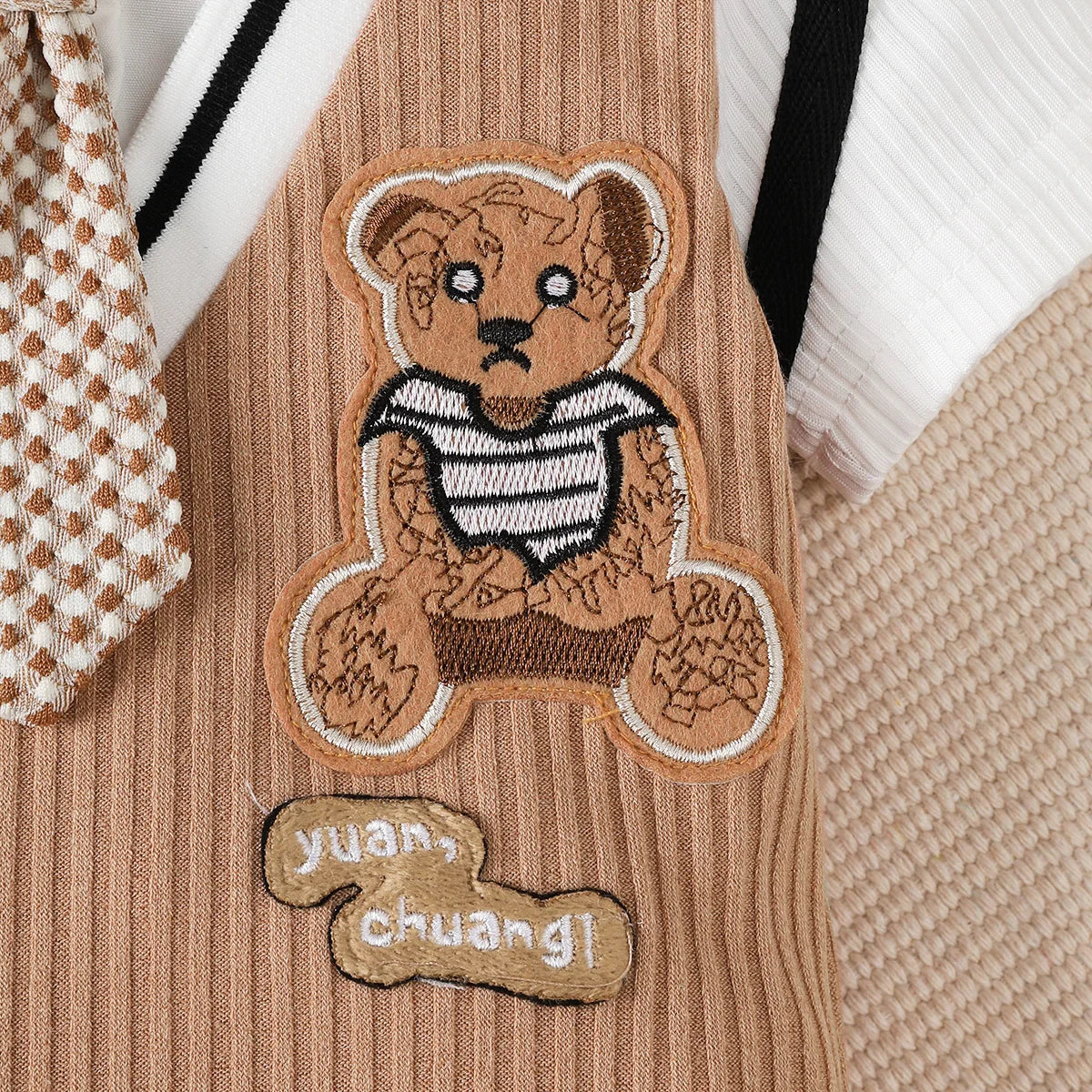 Baby boy wearing a smart short-sleeve romper with an attached tie