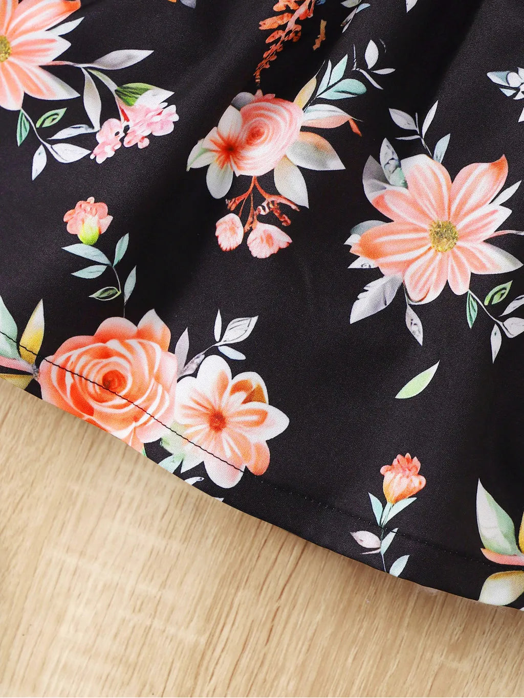 Baby girl wearing a sleeveless floral party dress with a bow