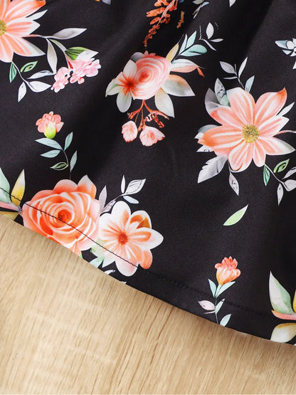Baby girl wearing a sleeveless floral party dress with a bow