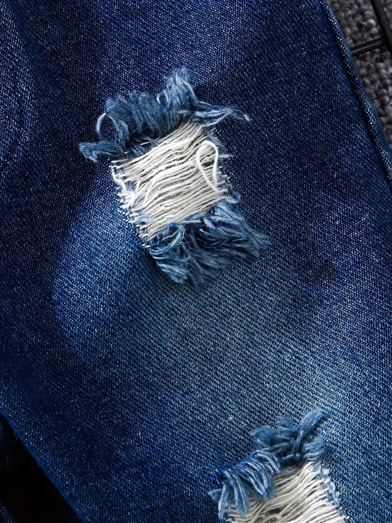 Fabric and texture detail of boys tartan polo shirt & denim trousers set