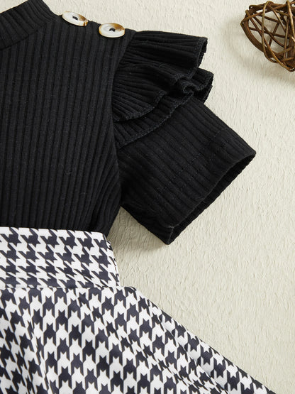 Close up detail of baby girls houndstooth romper dress set