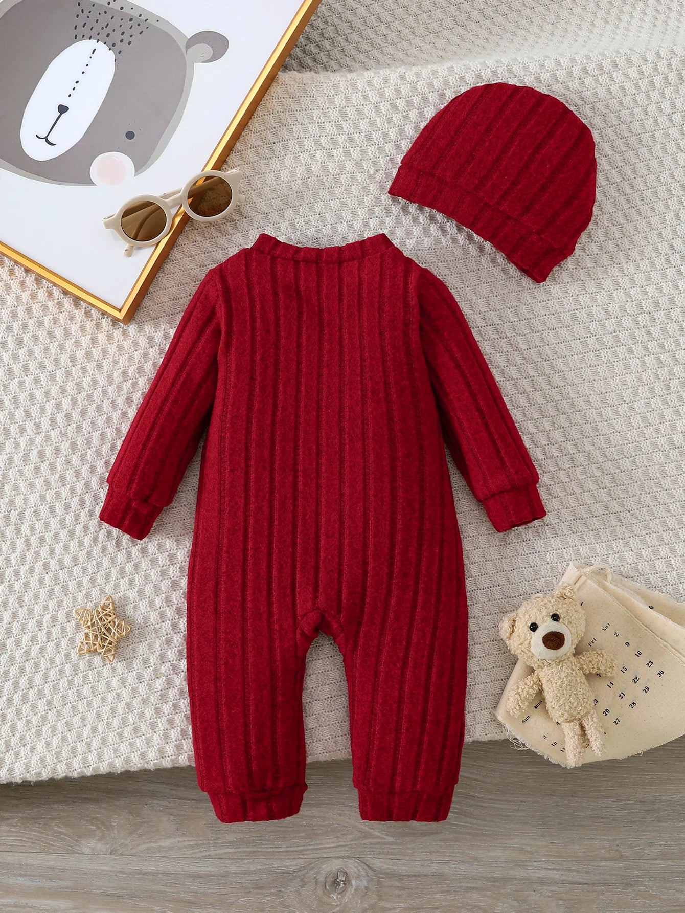 Detail view showing the fabric finish and pattern of the baby red bear badge winter onesie and hat set