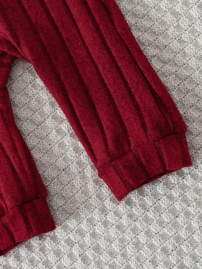 Fabric and texture detail of baby boys red bear badge onesie & hat set