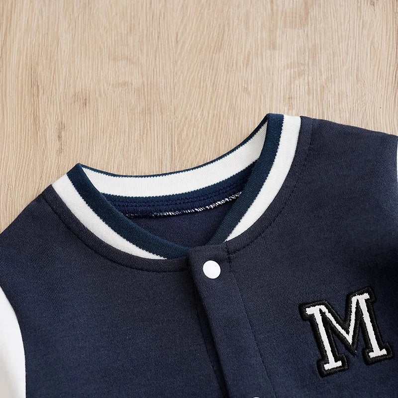 Close up highlighting the hem and stitching on the baby boys cotton baseball romper