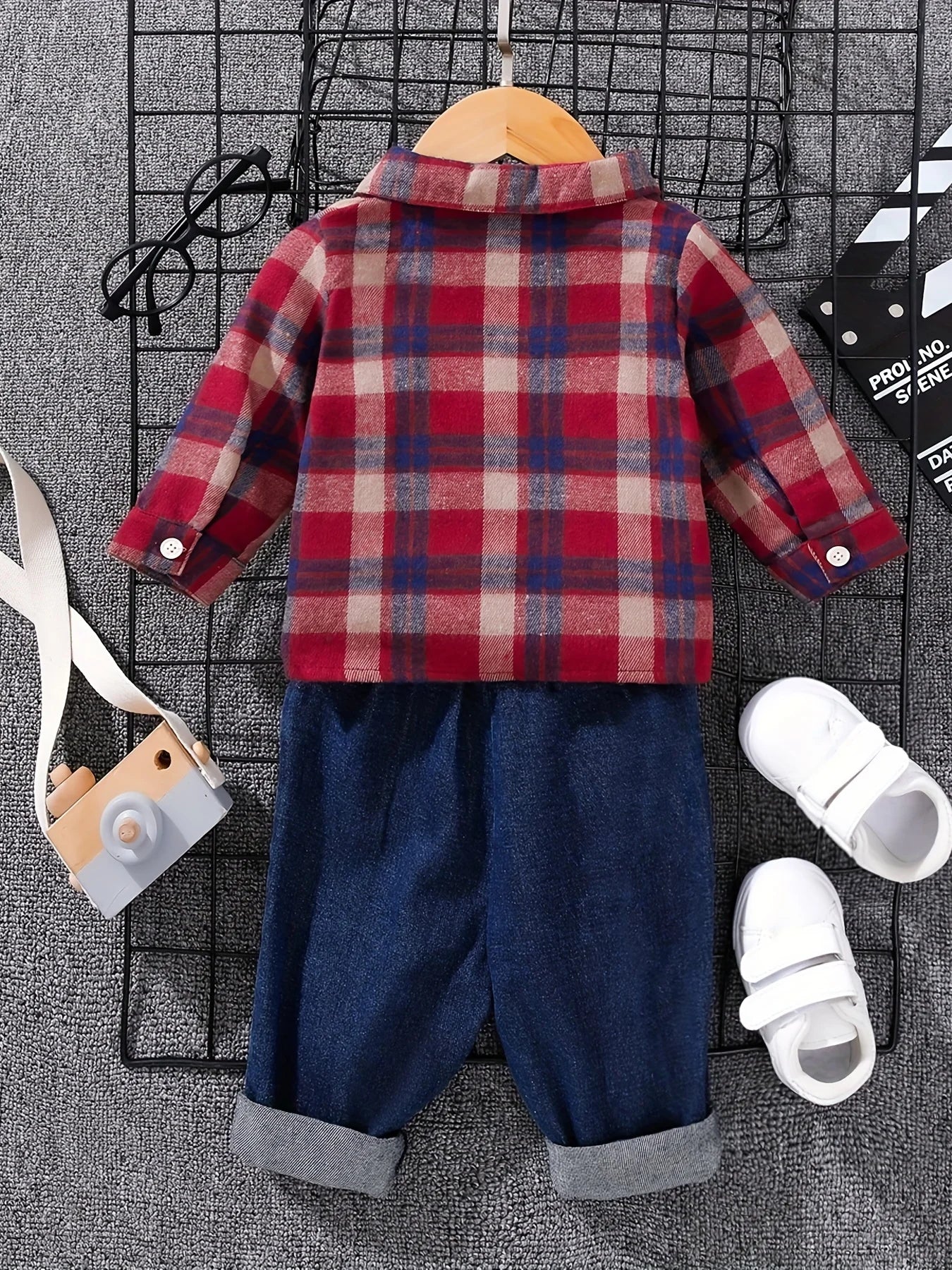 Side view of boys tartan polo shirt & denim trousers set