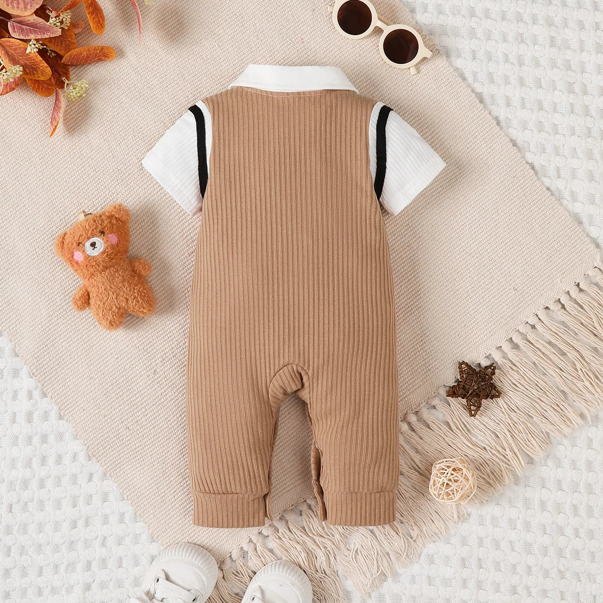 Baby boy wearing a smart short-sleeve romper with an attached tie