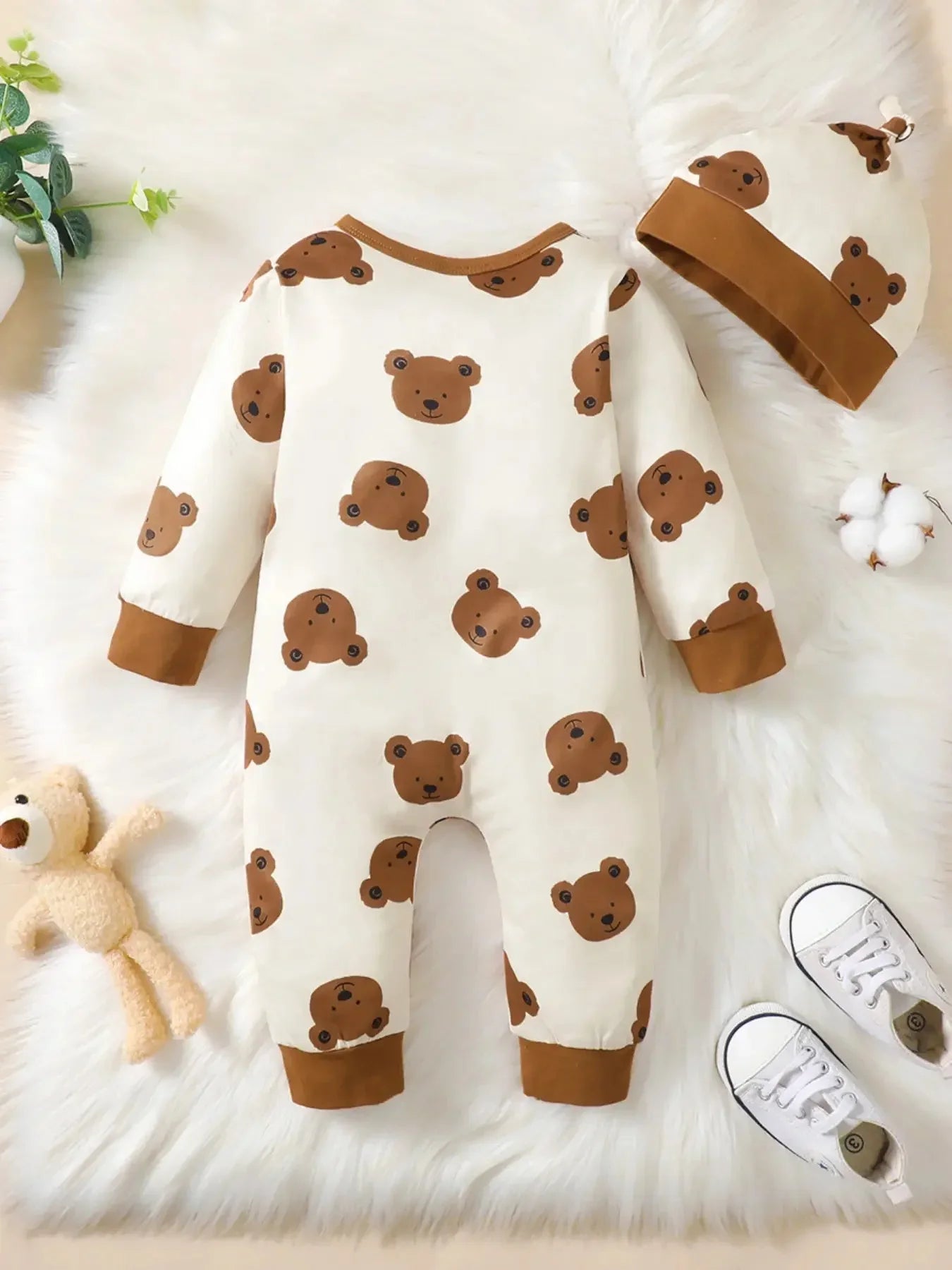 Close-up material detail of baby boys bear print button-up winter romper