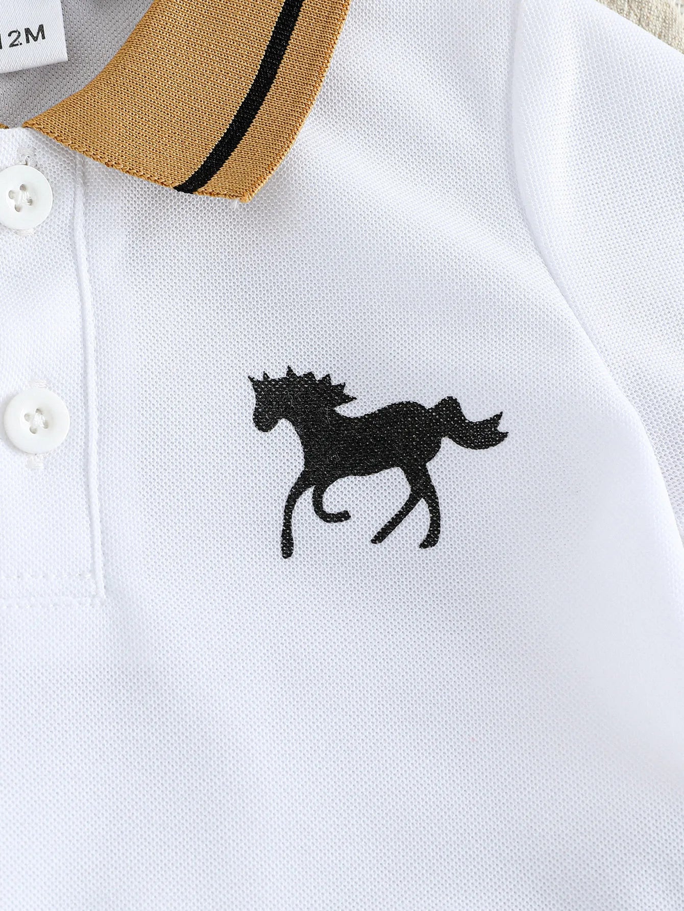 Close up highlighting the hem and stitching on the baby boys cartoon t-shirt and shorts summer set