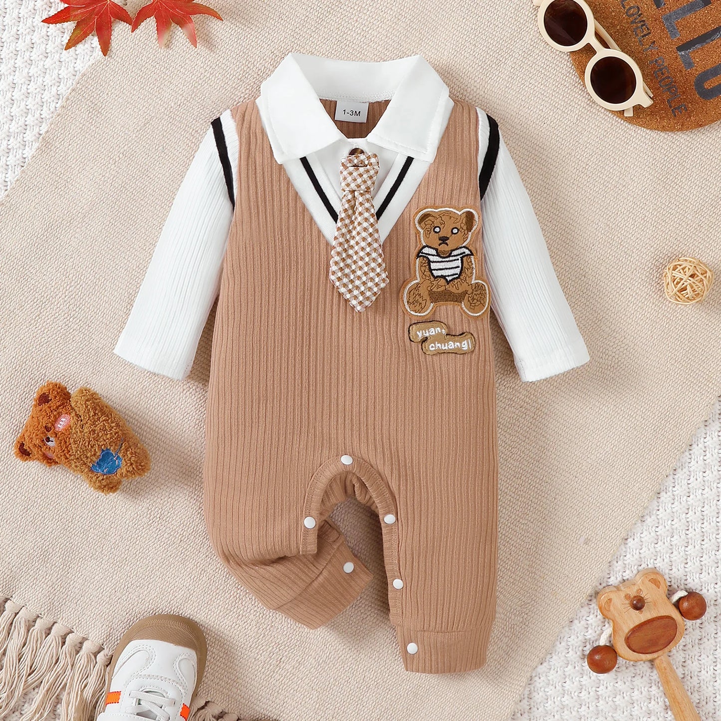 Baby boy wearing a smart short-sleeve romper with an attached tie