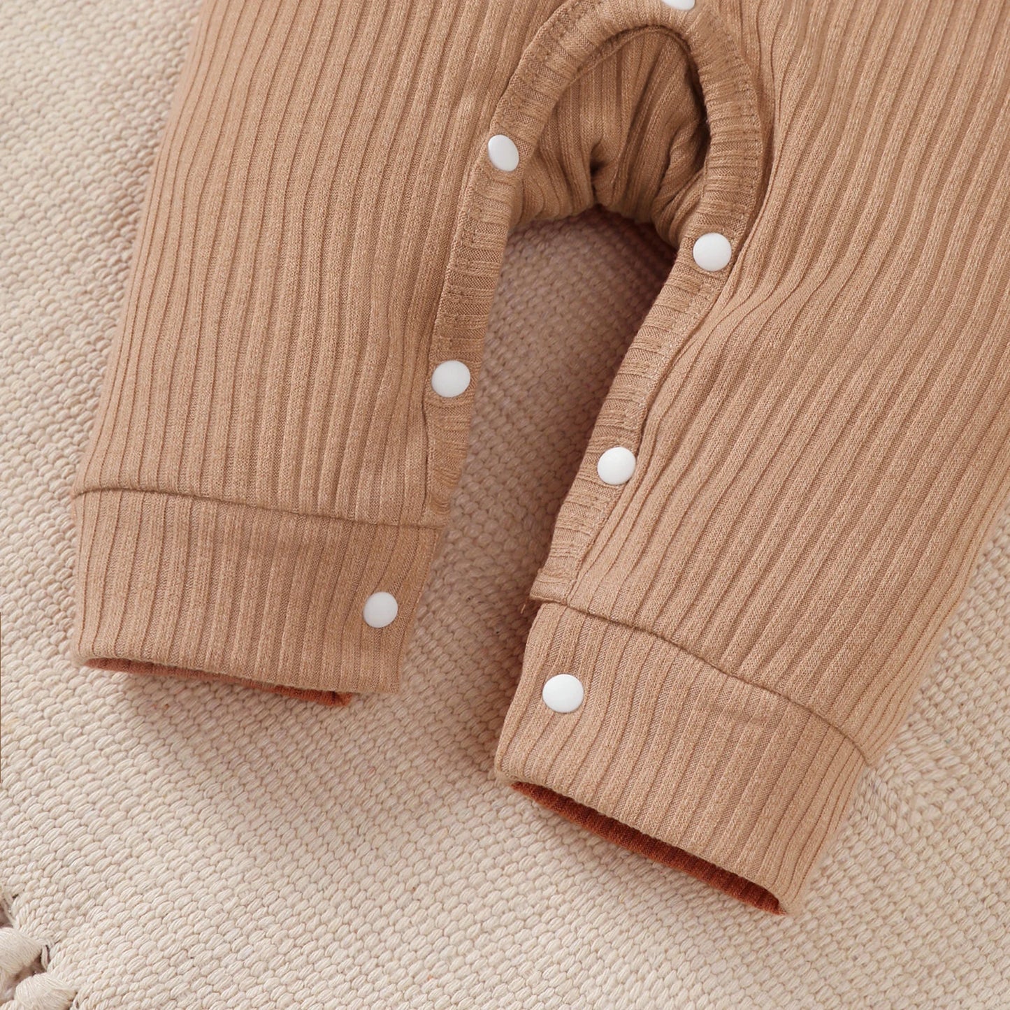 Baby boy wearing a smart short-sleeve romper with an attached tie