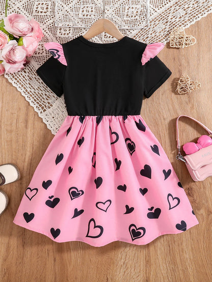 Girl wearing a mid-length dress with a cat and heart print and flutter sleeves
