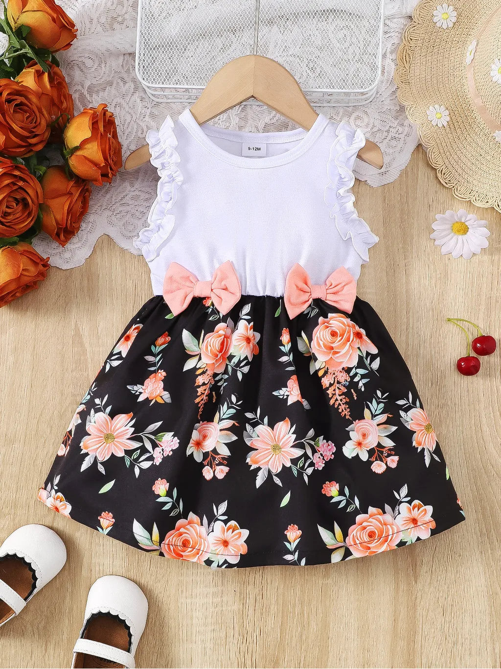Baby girl wearing a sleeveless floral party dress with a bow