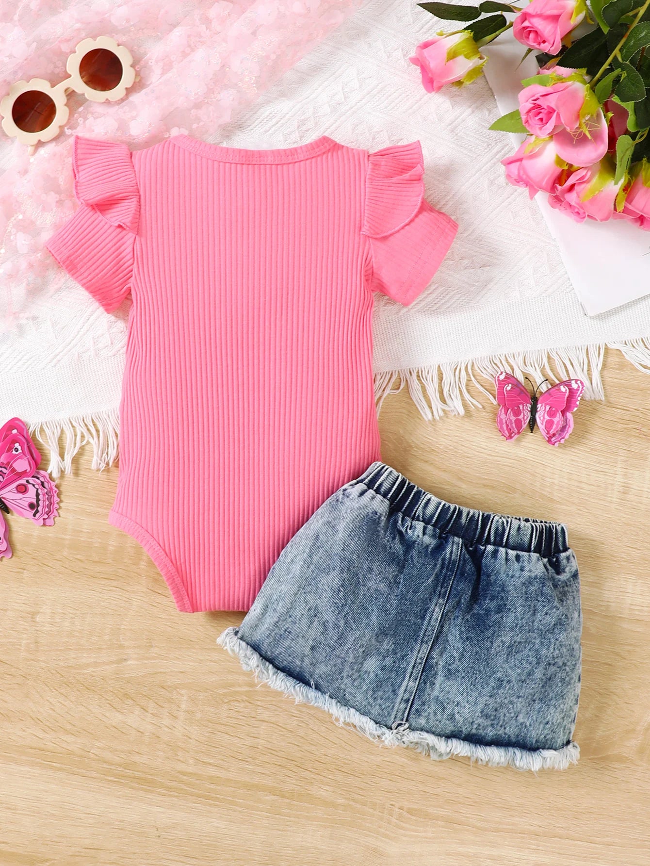 Back or secondary profile shot of the baby girls letter print romper and denim skirt set