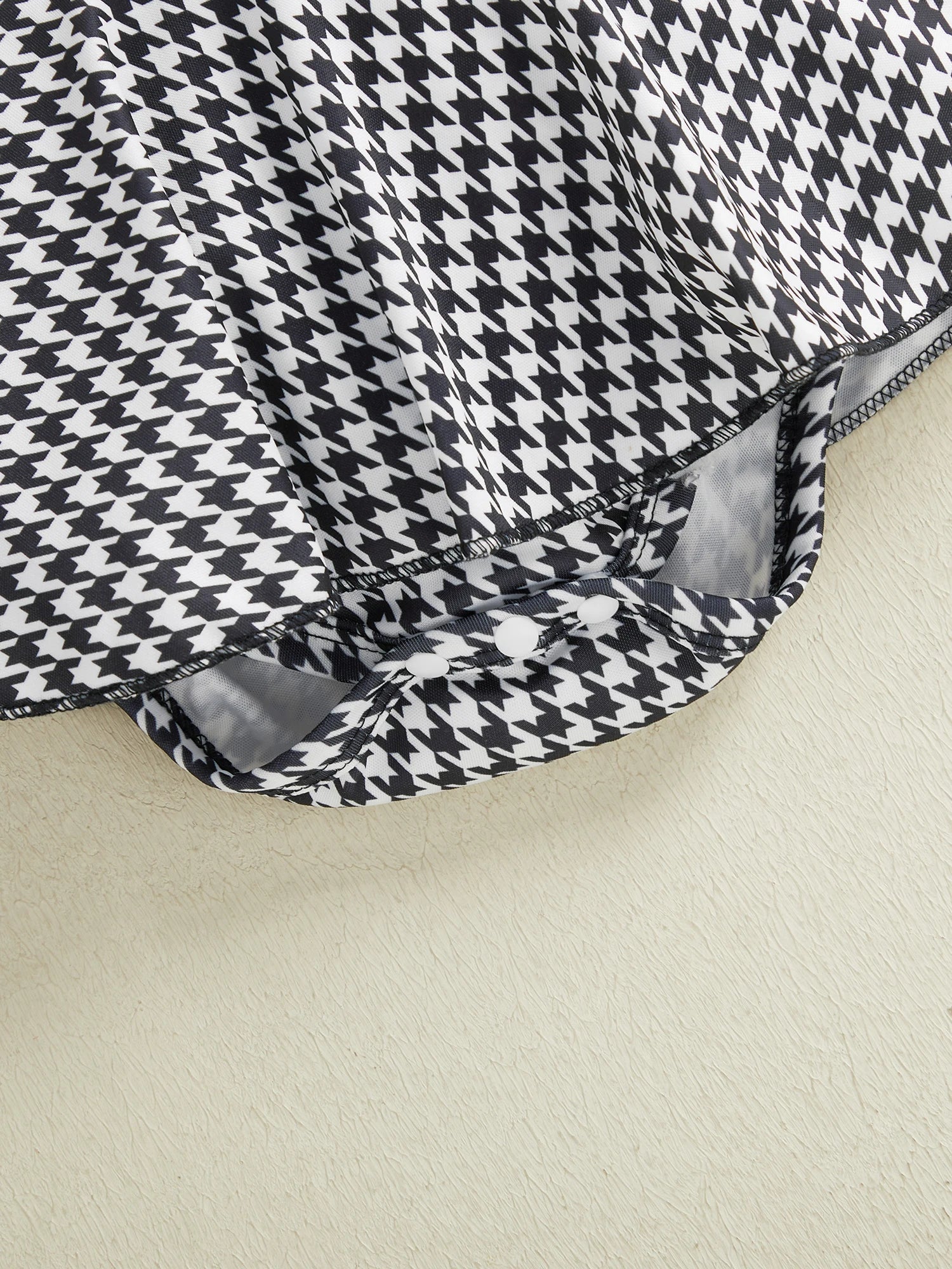 Fabric and texture detail of baby girls houndstooth romper dress set