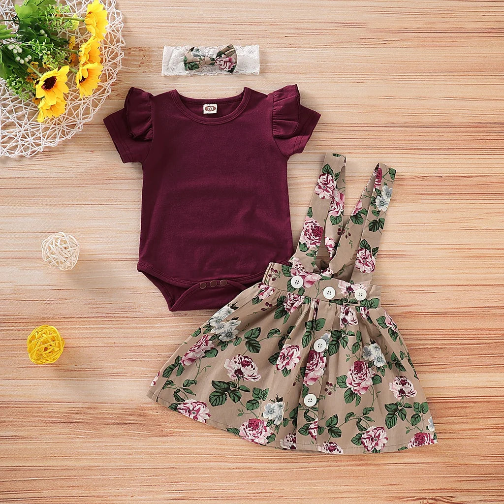 Detail view showing the fabric finish and pattern of the baby girls christmas floral romper and suspender skirt set