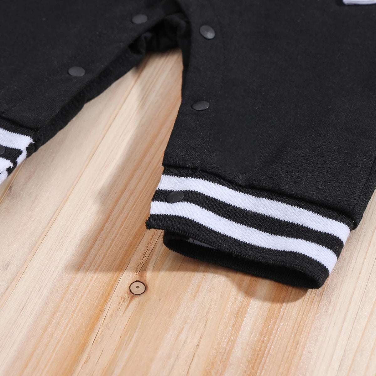 Fabric and texture detail of baby boys hooded baseball romper jumpsuit