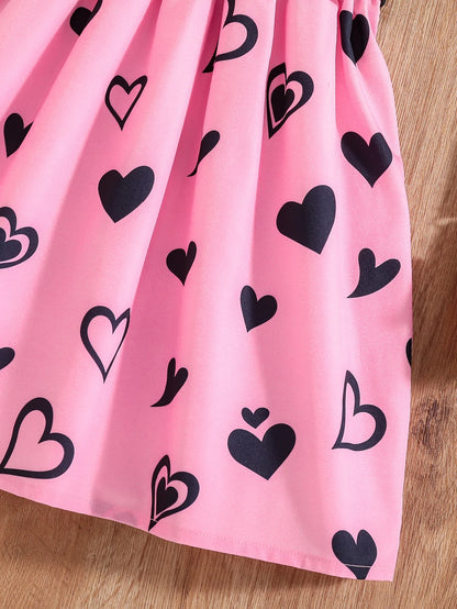 Girl wearing a mid-length dress with a cat and heart print and flutter sleeves