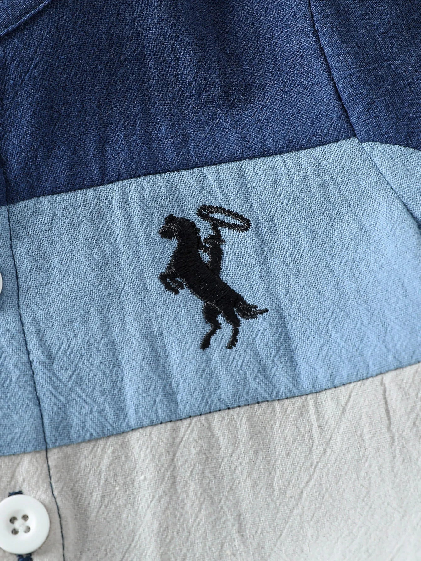 Close up highlighting the hem and stitching on the baby boys patchwork short sleeve shirt and shorts set
