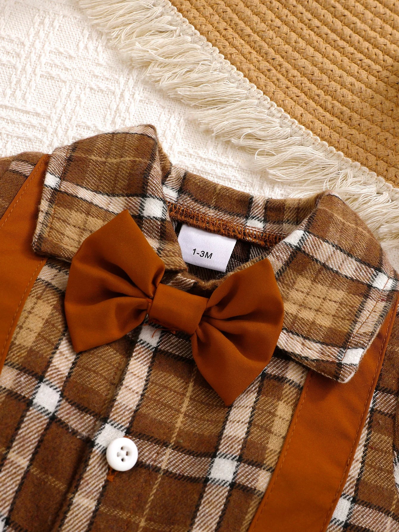 Close up detail of baby boys plaid jumpsuit with bow tie & beret