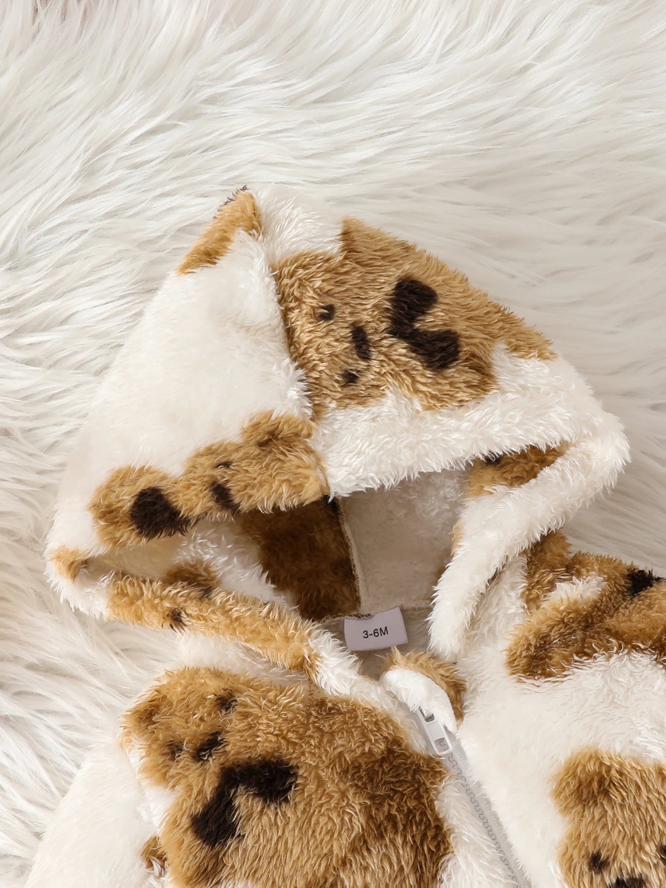 Close-up material detail of baby girls fluffy teddy bear print onesie